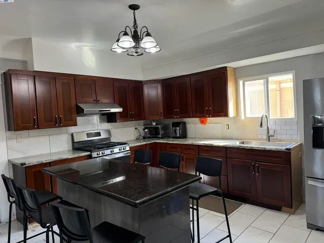 a kitchen with a stove a sink a microwave and cabinets
