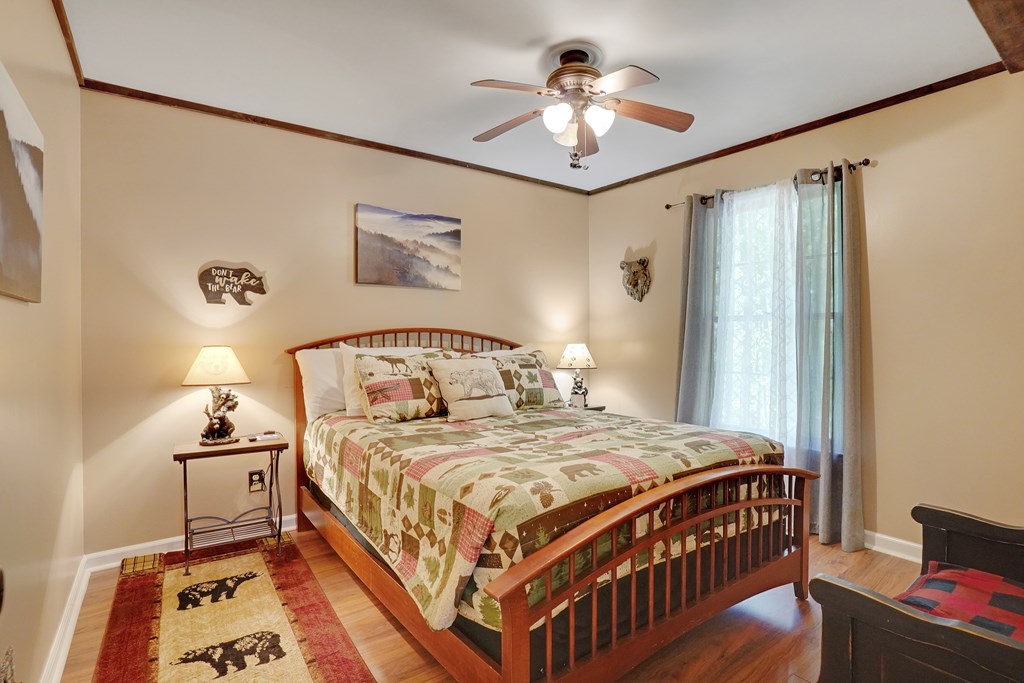 41 Courtside Court Ellijay, GA 30540 - Photo 12 of 34 a bedroom with a bed and a chandelier
