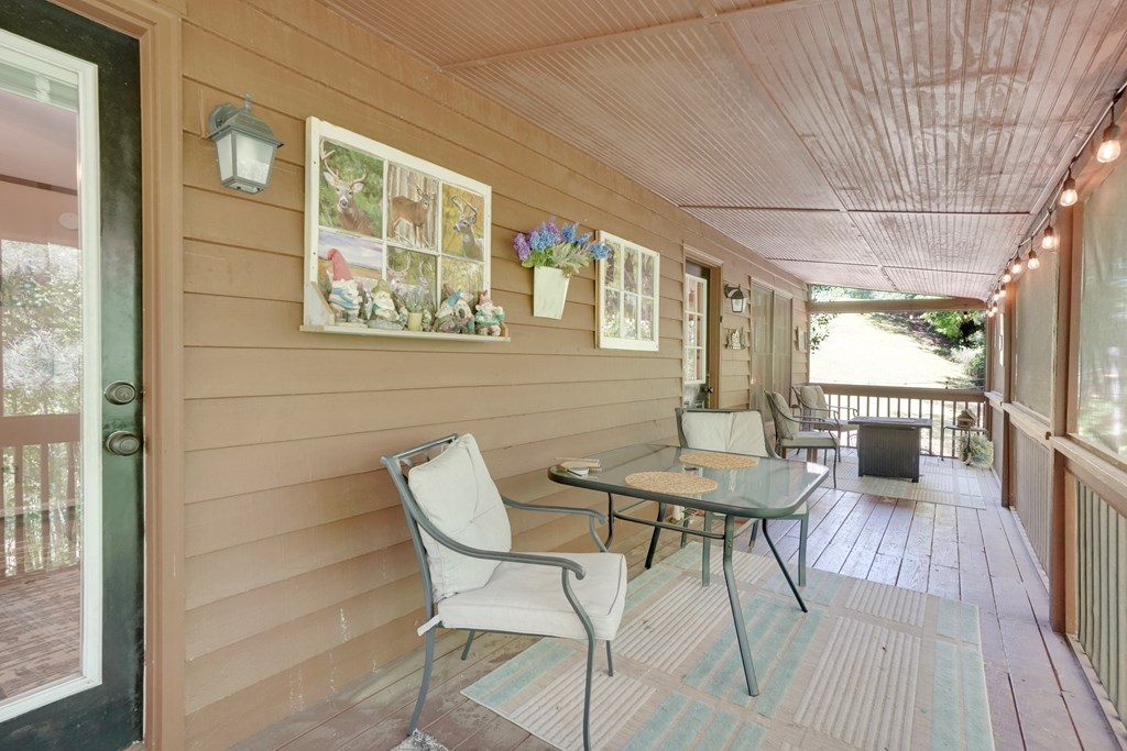 41 Courtside Court Ellijay, GA 30540 - Photo 18 of 34 a view of a patio with table and chairs with wooden floor and wall