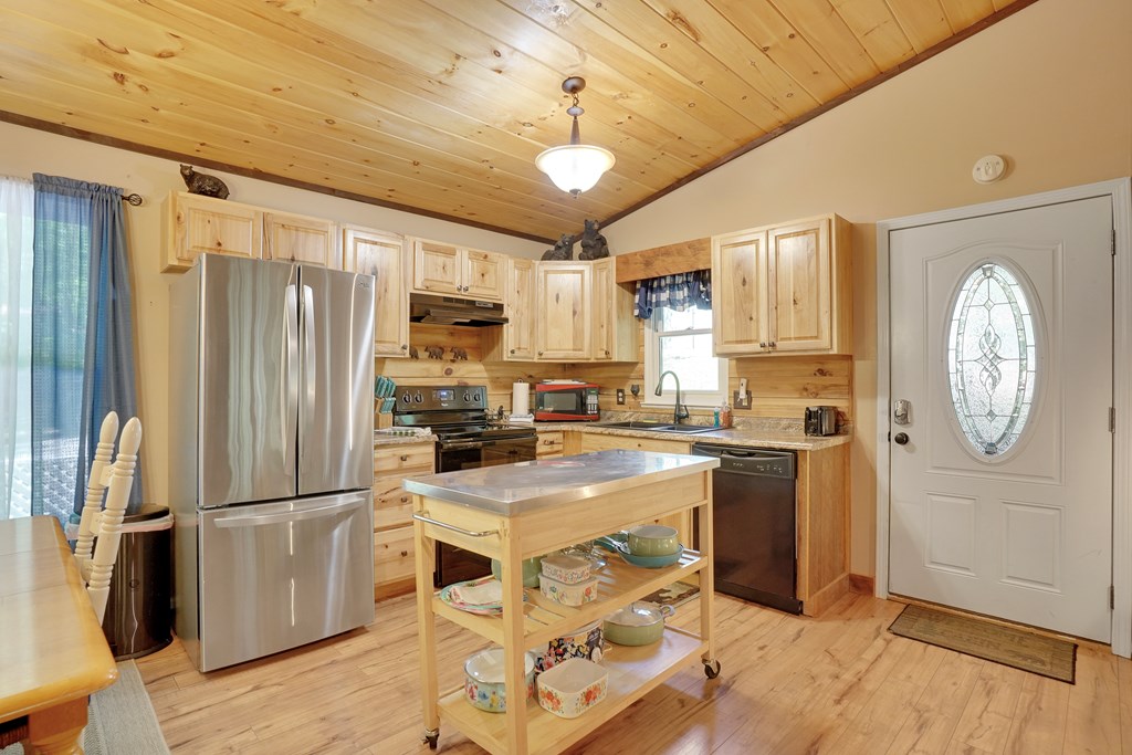 41 Courtside Court Ellijay, GA 30540 - Photo 6 of 34 a kitchen with granite countertop a refrigerator a stove a sink dishwasher and white cabinets with wooden floor