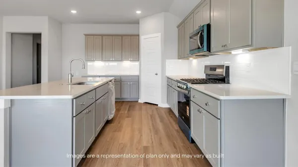 a kitchen with kitchen island granite countertop a sink a counter top space stainless steel appliances and cabinets