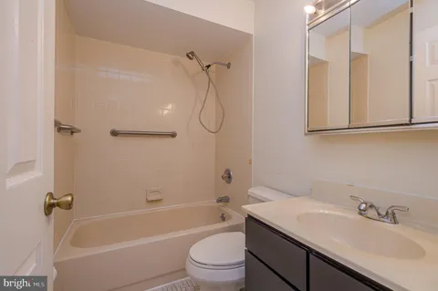 a bathroom with a granite countertop sink a toilet and shower