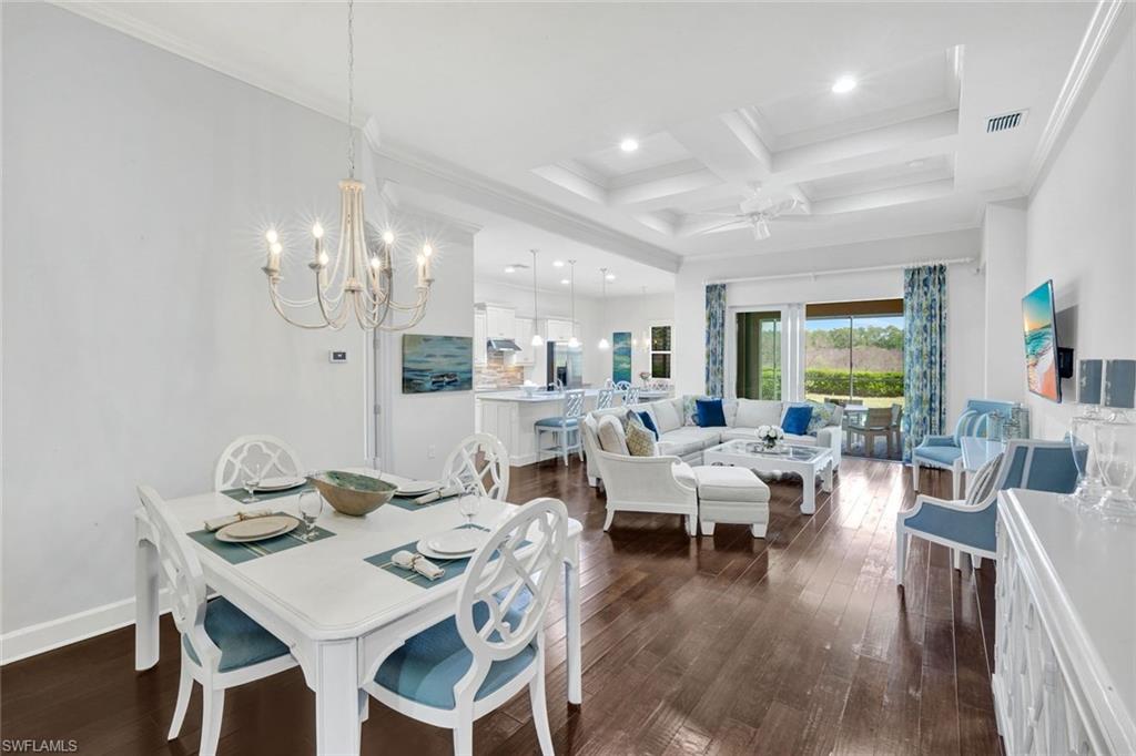 9311 Fieldstone Lane Naples, FL 34120 - Photo 14 of 48 a view of a dining room with furniture a chandelier and wooden floor