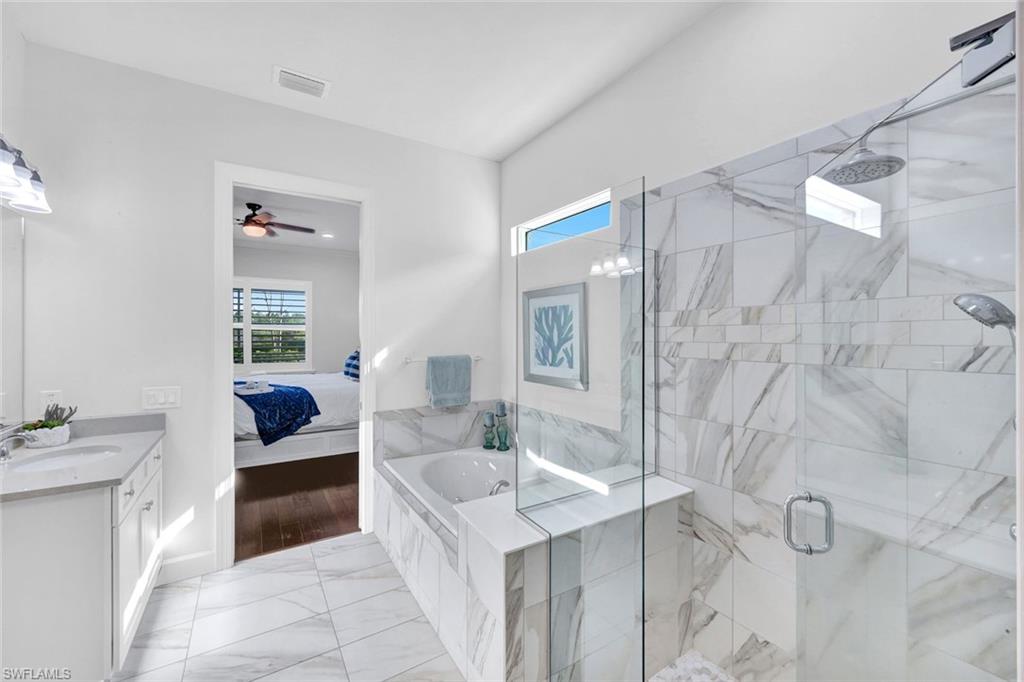 9311 Fieldstone Lane Naples, FL 34120 - Photo 19 of 48 a spacious bathroom with a tub sink and mirror
