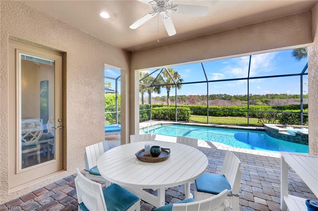9311 Fieldstone Lane Naples, FL 34120 - Photo 26 of 48 a dining room with furniture and a floor to ceiling window