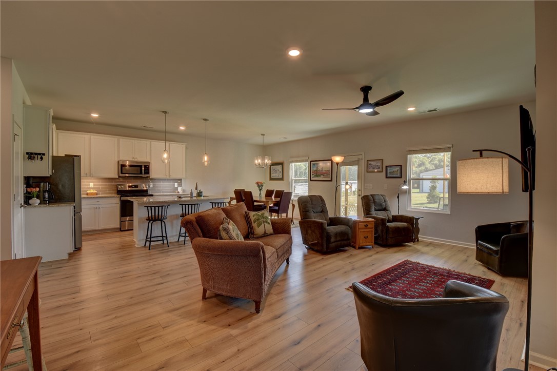 220 Clinkscales Road Anderson, SC 29624 - Photo 6 of 33 Warm wood floors flow seamlessly through this open-concept living area and kitchen layout.