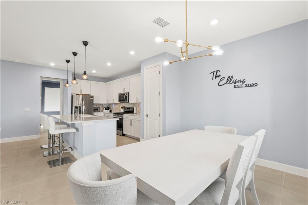 20250 Napa Loop Estero, FL 33928 - Photo 5 of 33 a kitchen with kitchen island a white cabinets and refrigerator