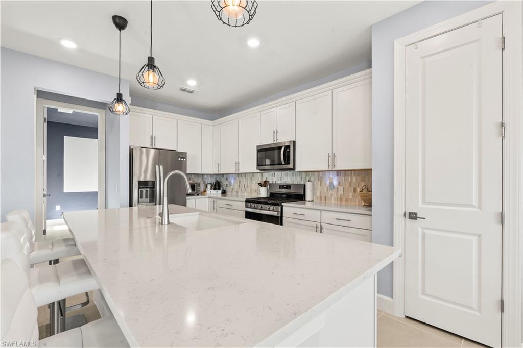 20250 Napa Loop Estero, FL 33928 - Photo 6 of 33 a kitchen with stainless steel appliances granite countertop a sink a stove and a refrigerator