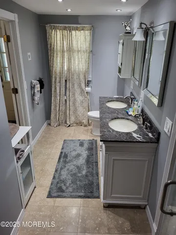 a bathroom with a granite countertop sink a mirror and shower