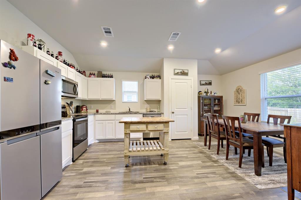 420 Jameson Springtown, TX 76082 - Photo 11 of 29 a kitchen with granite countertop a refrigerator a stove a dining table and chairs