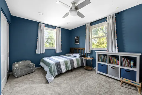 a spacious bedroom with a bed and a book shelf