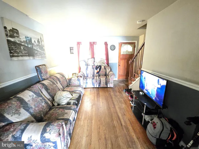a living room with furniture a flat screen tv and a floor to ceiling window