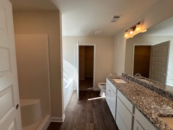 a bathroom with a granite countertop sink and a large mirror