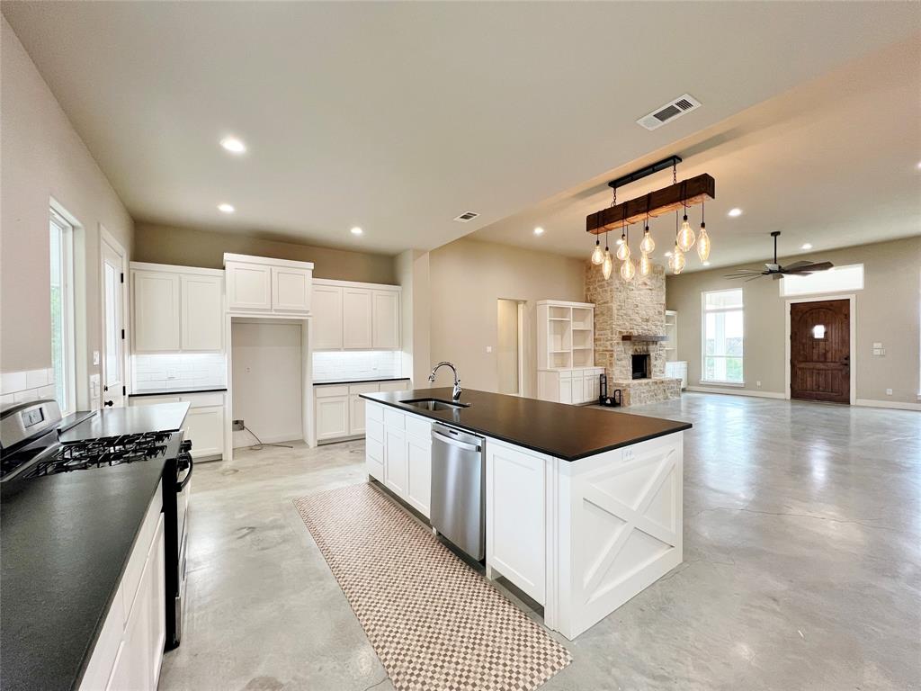a kitchen with stainless steel appliances kitchen island granite countertop a sink and cabinets