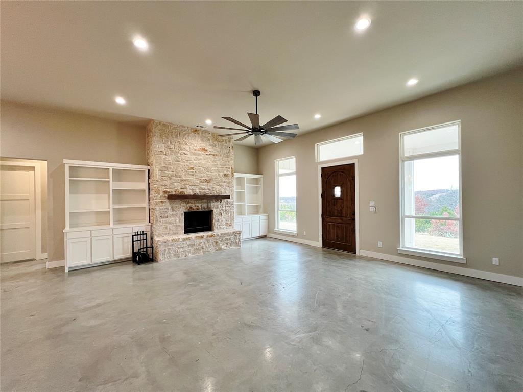 1141 Veal Station Road Springtown, TX 76082 - Photo 3 of 24 an empty room with fireplace and windows