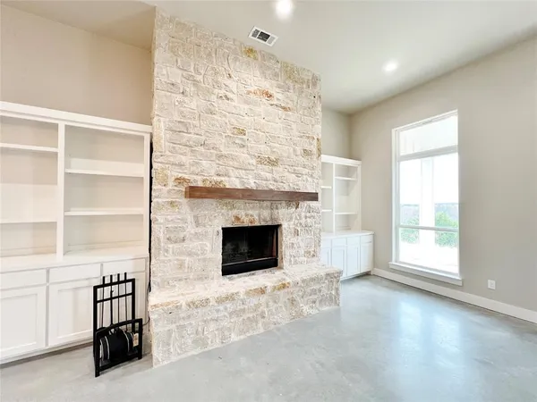 a view of empty room with a fireplace and window
