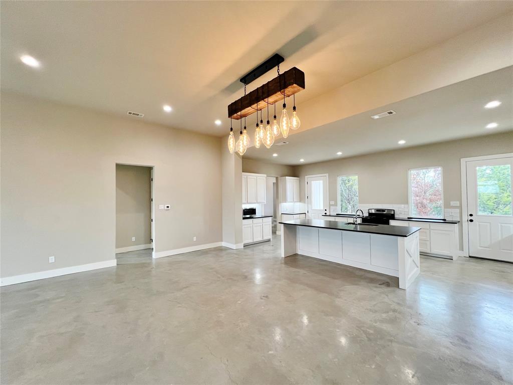 1141 Veal Station Road Springtown, TX 76082 - Photo 6 of 24 a large kitchen with a large counter top space a sink stainless steel appliances and cabinets
