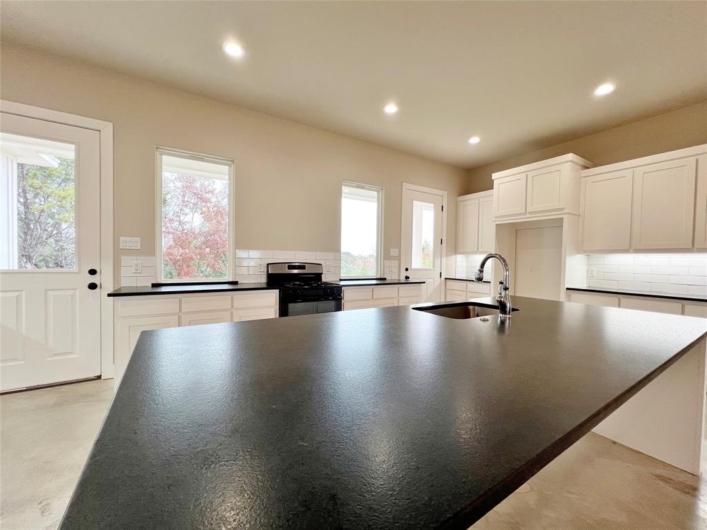 1141 Veal Station Road Springtown, TX 76082 - Photo 7 of 24 a view of a kitchen with swimming pool and a stove top oven