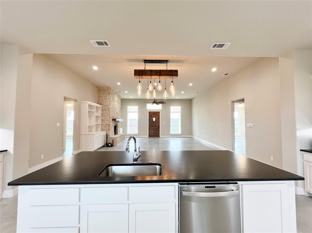 1141 Veal Station Road Springtown, TX 76082 - Photo 8 of 24 a large kitchen with kitchen island a sink stainless steel appliances and cabinets