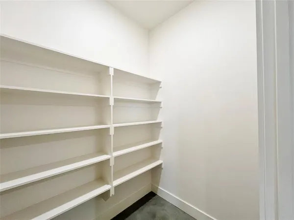 a view of walk in closet with empty racks