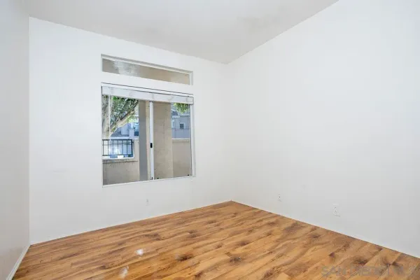 a view of a room with wooden floor and window