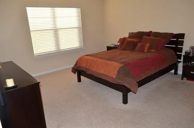 a bedroom with a bed window and mirror