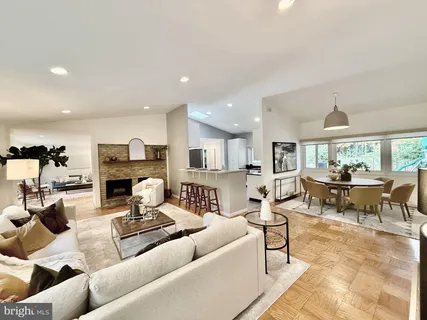 a living room with furniture and a dining table with kitchen view