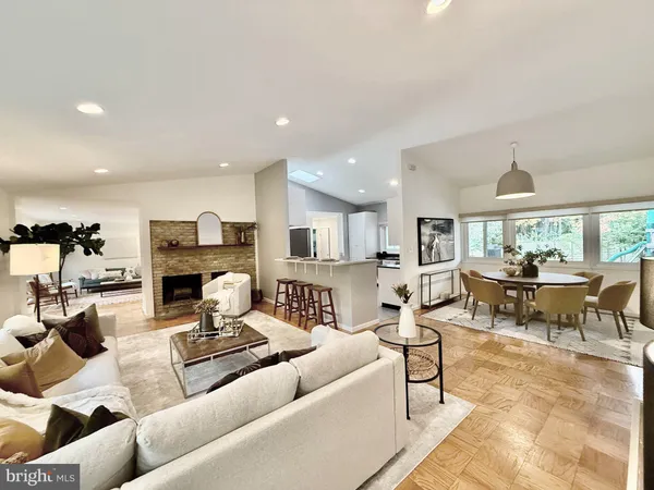 a living room with furniture and a dining table with kitchen view