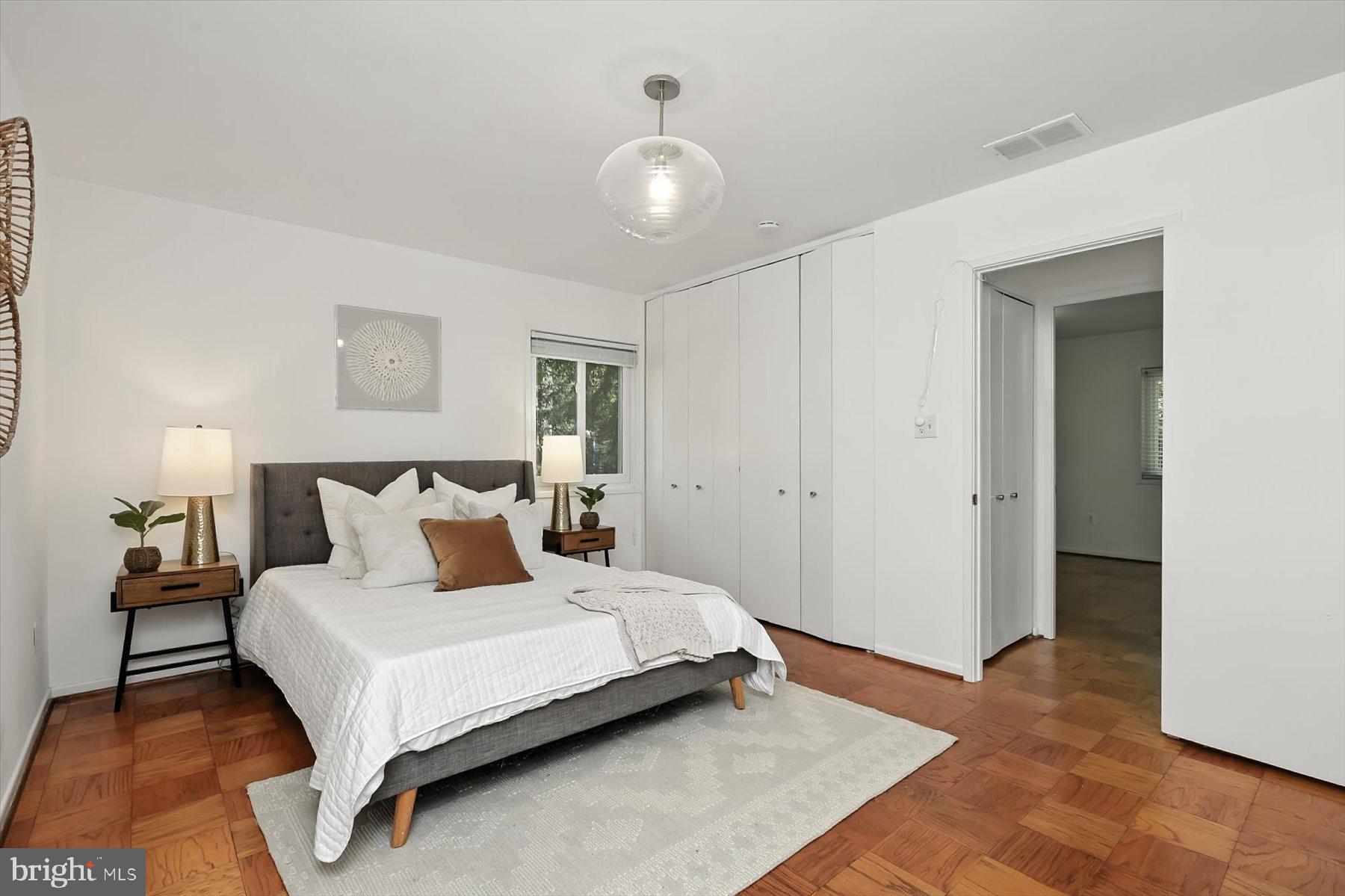 8216 Fenway Road Bethesda, MD 20817 - Photo 35 of 65 a bedroom with a large bed and a chandelier