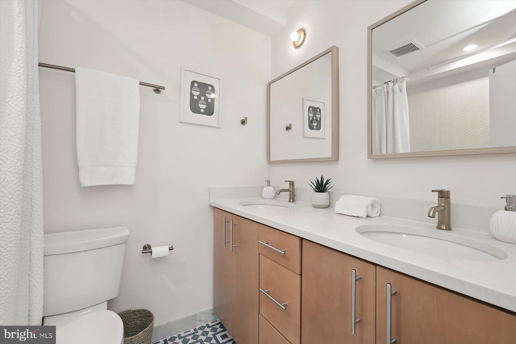 8216 Fenway Road Bethesda, MD 20817 - Photo 41 of 65 a bathroom with a toilet sink and mirror