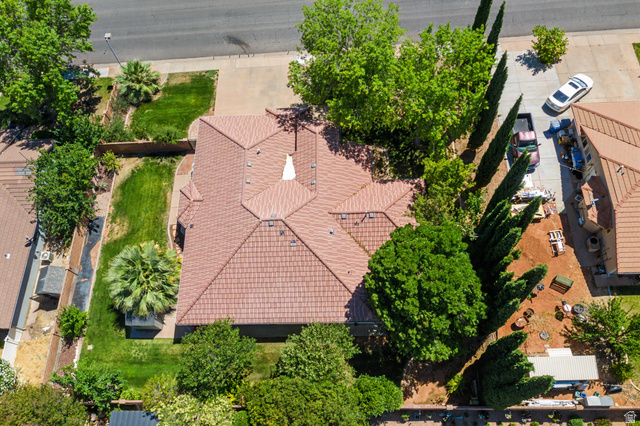 3034 Swiss Drive Santa Clara, UT 84765 - Photo 59 of 59 Property featuring a terracotta tile roof, a verdant lawn, mature trees, a paved driveway, and a perimeter fence