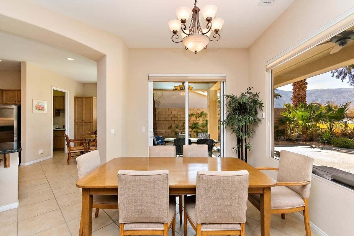 81086 Barrel Cactus Road La Quinta, CA 92253 - Photo 18 of 36 a dining room with furniture a large window and potted plants