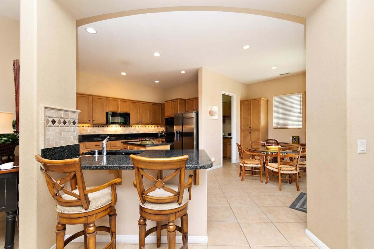81086 Barrel Cactus Road La Quinta, CA 92253 - Photo 19 of 36 a kitchen with stainless steel appliances kitchen island granite countertop a sink and cabinets