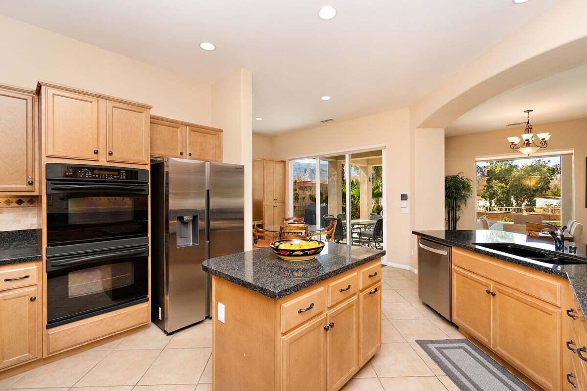 81086 Barrel Cactus Road La Quinta, CA 92253 - Photo 21 of 36 a kitchen with granite countertop a refrigerator stove and sink