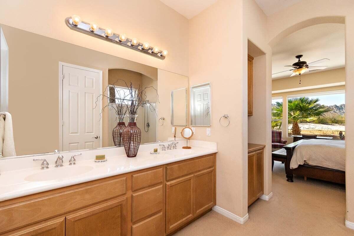 81086 Barrel Cactus Road La Quinta, CA 92253 - Photo 29 of 36 a en suite bathroom with a double vanity sink and a mirror