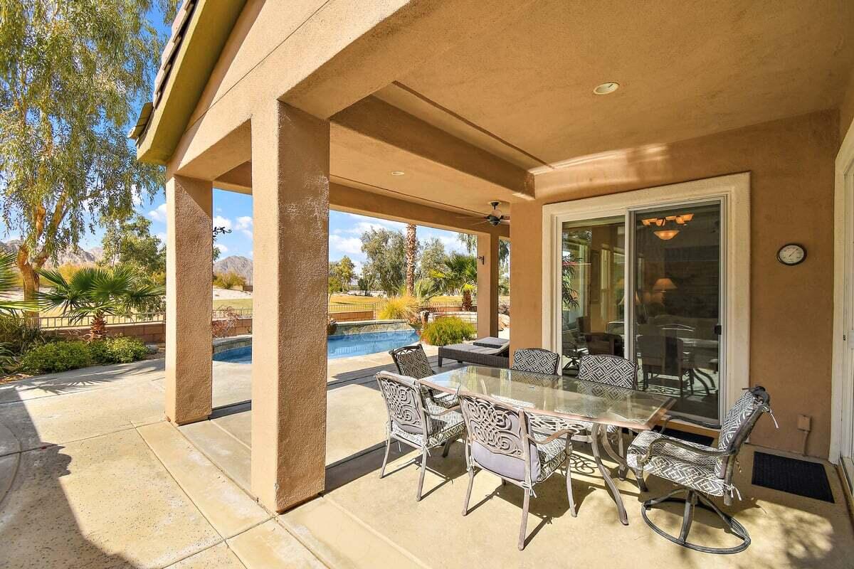 81086 Barrel Cactus Road La Quinta, CA 92253 - Photo 8 of 36 a view of a patio with table and chairs and floor to ceiling window