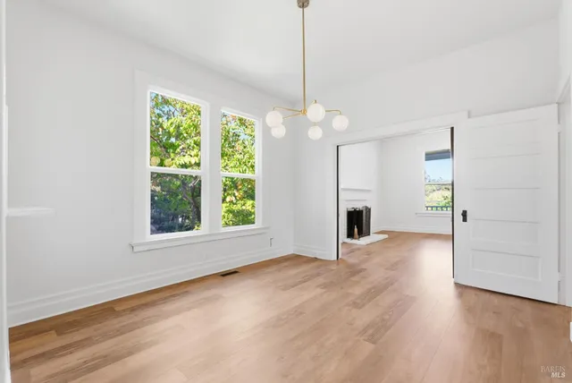 a view of an empty room with wooden floor