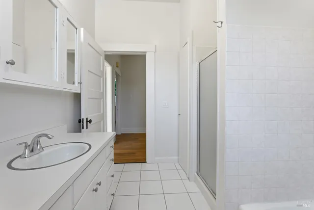 a view of large kitchen with stainless steel appliances granite countertop a stove a sink and white cabinets
