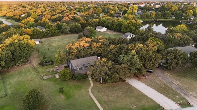 an aerial view of a house with a yard and lake view