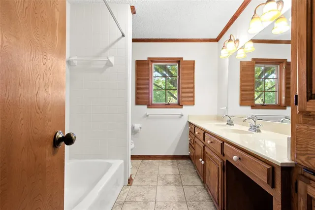 a spacious bathroom with a tub sink and mirror