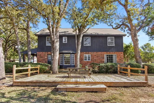 an aerial view of a house with a yard and lake view