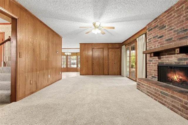 a view of an empty room with window and fireplace
