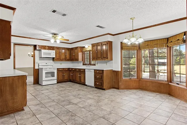 a large kitchen with stainless steel appliances a sink and cabinets