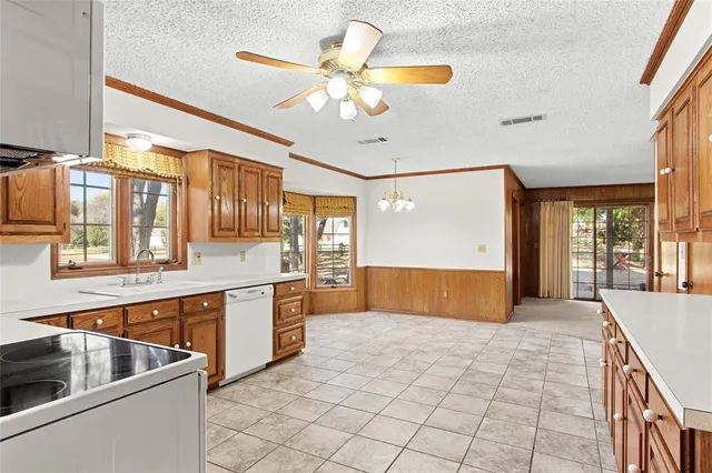 a large kitchen with stainless steel appliances granite countertop a sink and cabinets