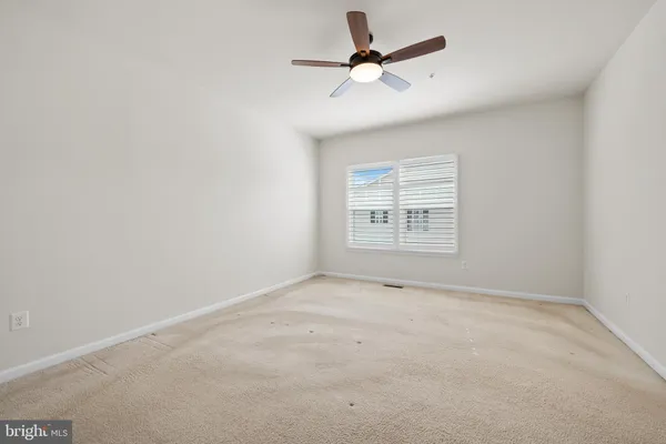 an empty room with a empty space and a ceiling fan