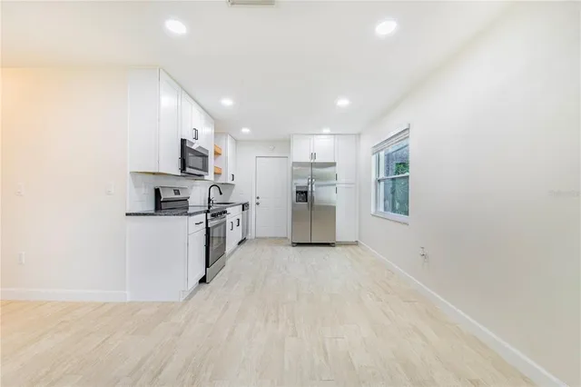 a view of kitchen with refrigerator and window