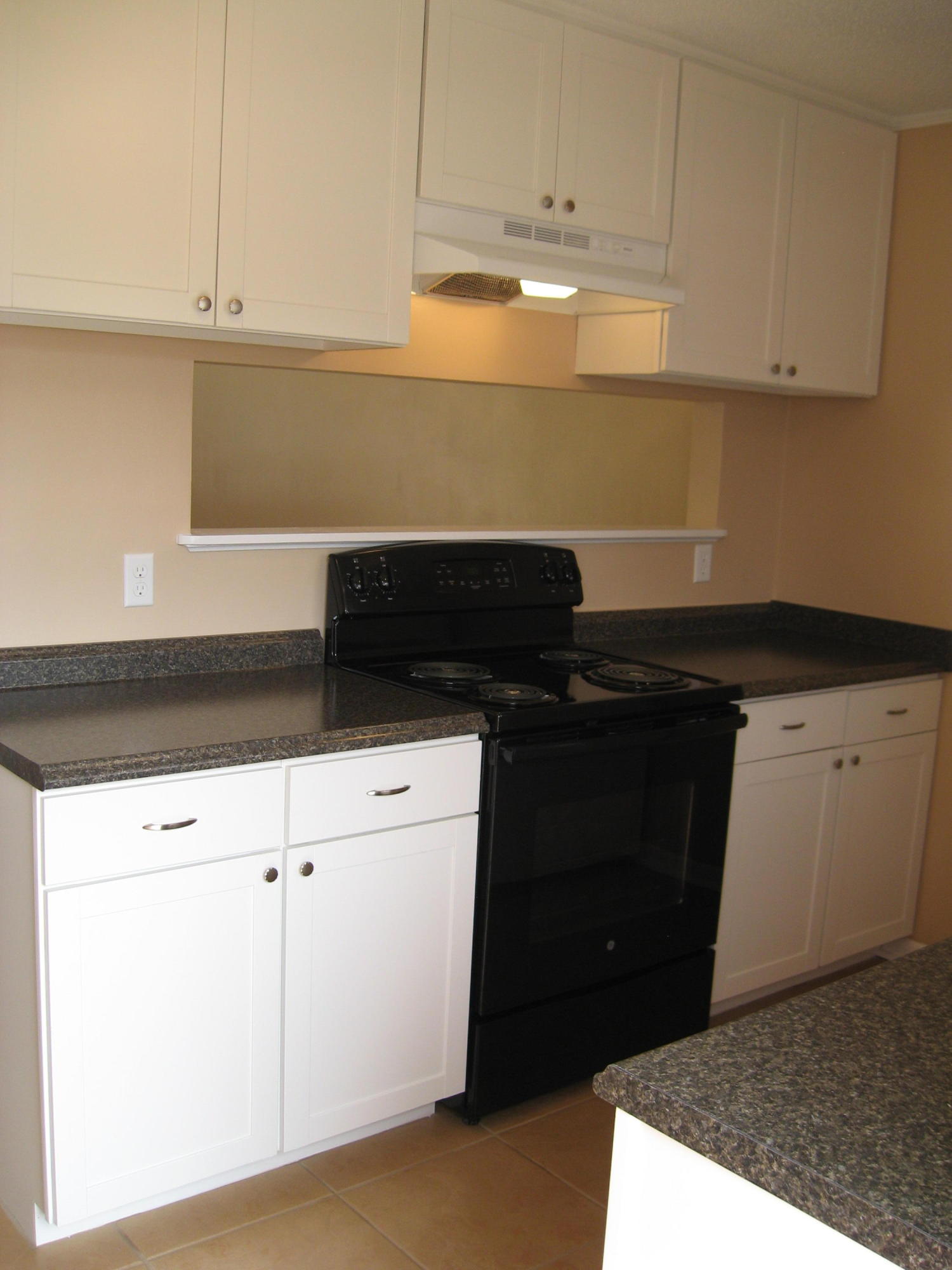 545 Hickory Avenue, Unit C Niceville, FL 32578 - Photo 5 of 11 a kitchen with granite countertop white cabinets and black appliances