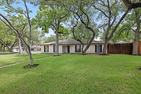 a view of a house with a yard and tree s