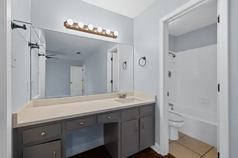 a spacious bathroom with a shower a sink and a mirror