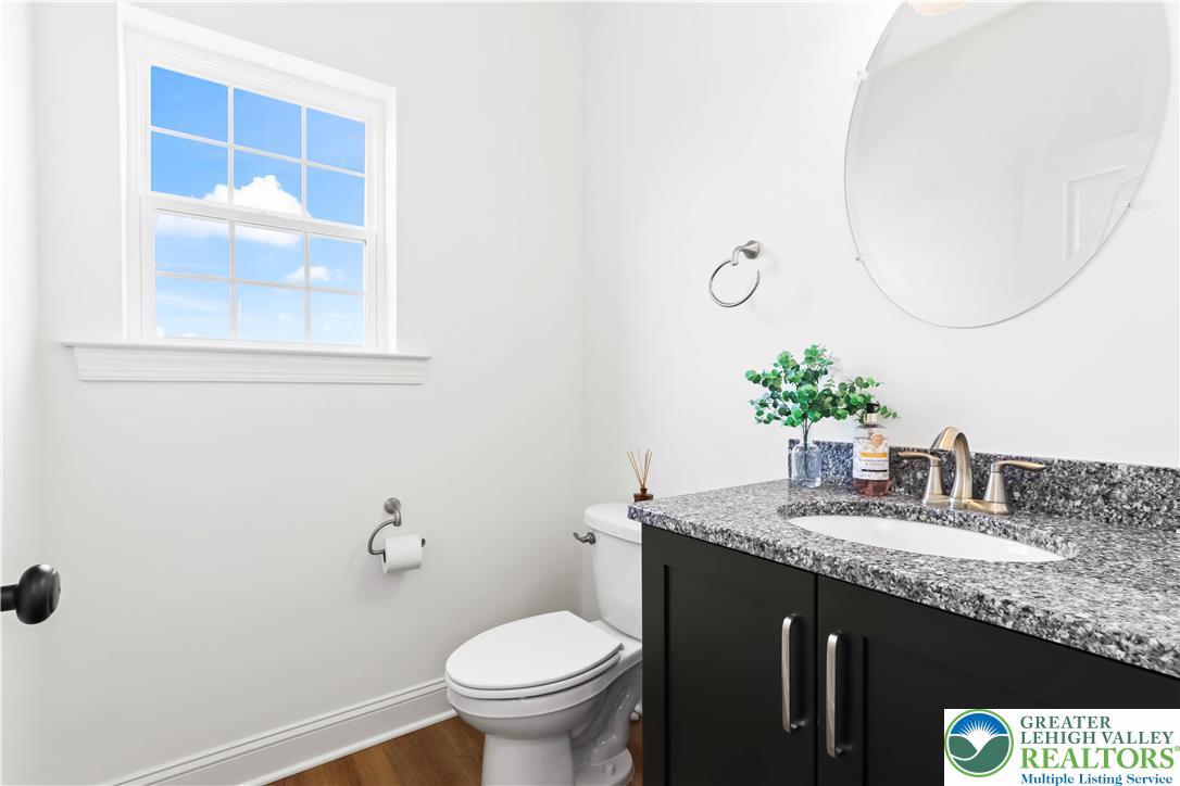 4450 Maple Street, Unit 2 Schnecksville, PA 18078 - Photo 14 of 45 a bathroom with a granite countertop sink a mirror and a toilet